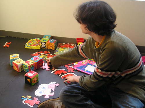 Mike DiStaula plays with infant toys while he waits for his cell phone